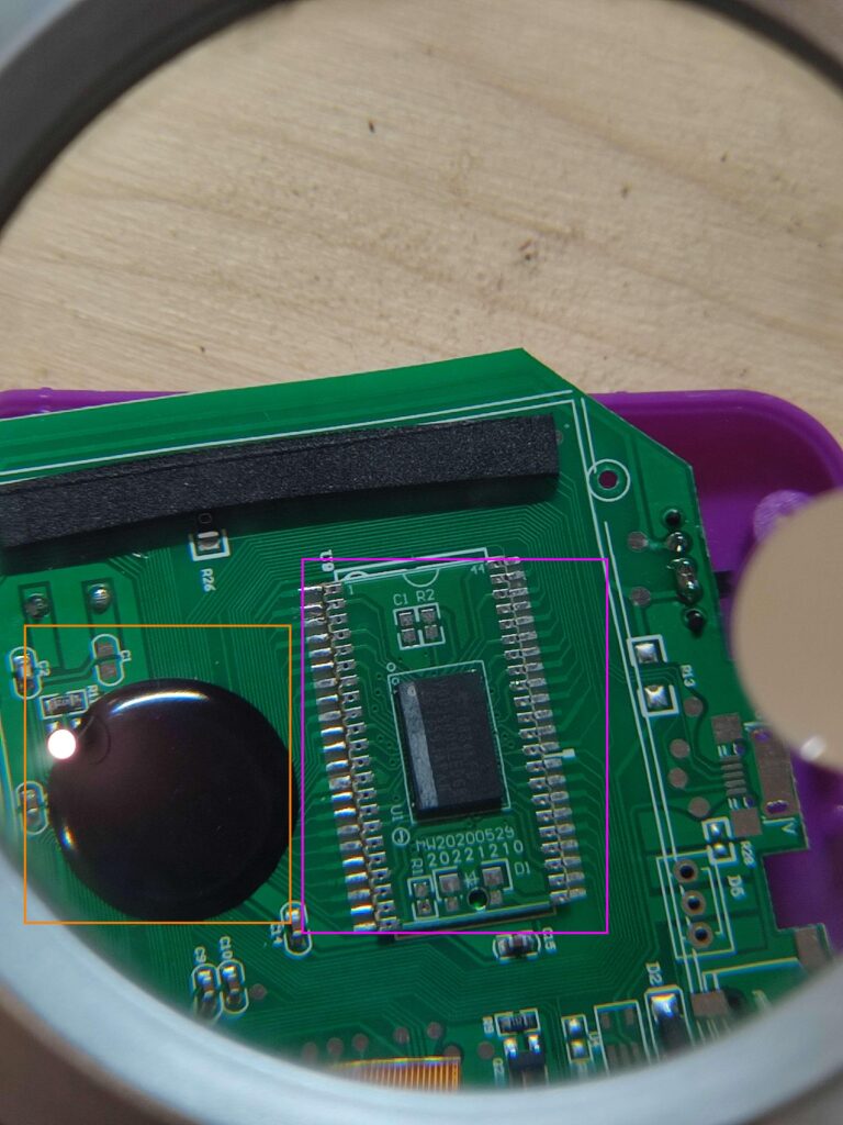 Carte électronique vue à la loupe : CPU sous epoxy encadré en orange et module MW20200529 encadré en rose