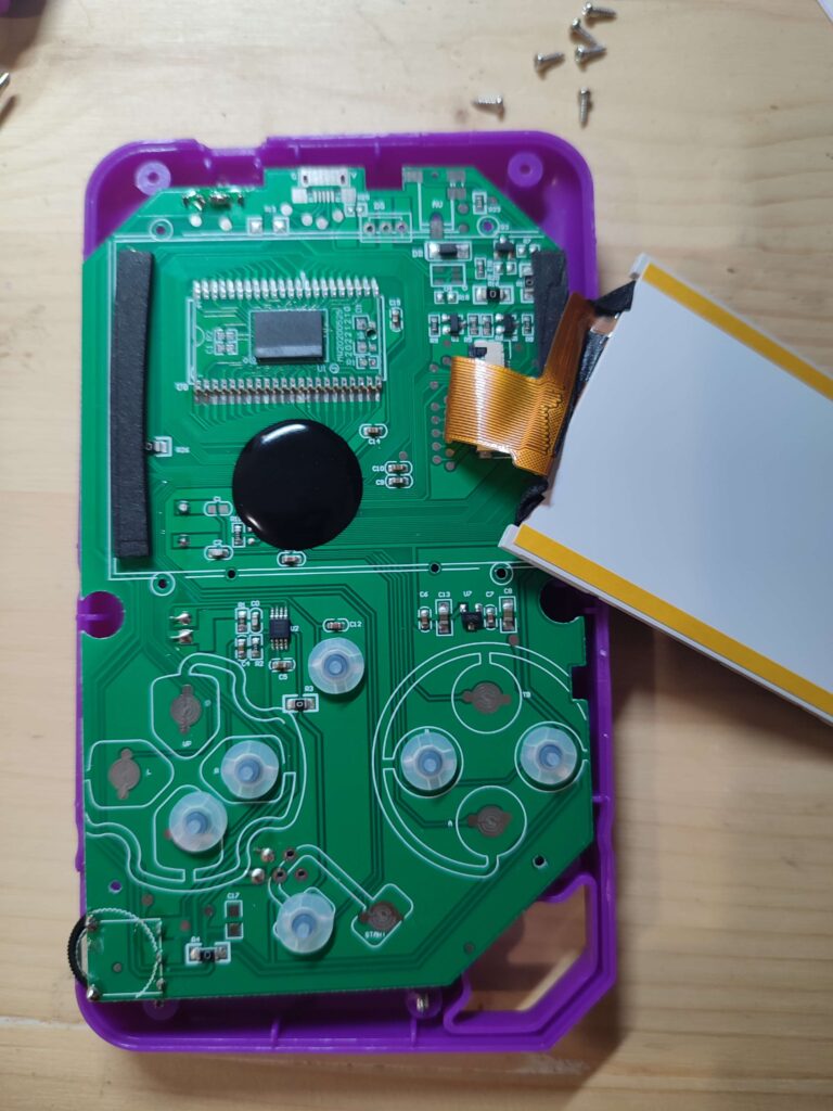 Carte électronique de la console démontée : CPU sous une goutte d'epoxy noire et module mémoire à 44 broches
